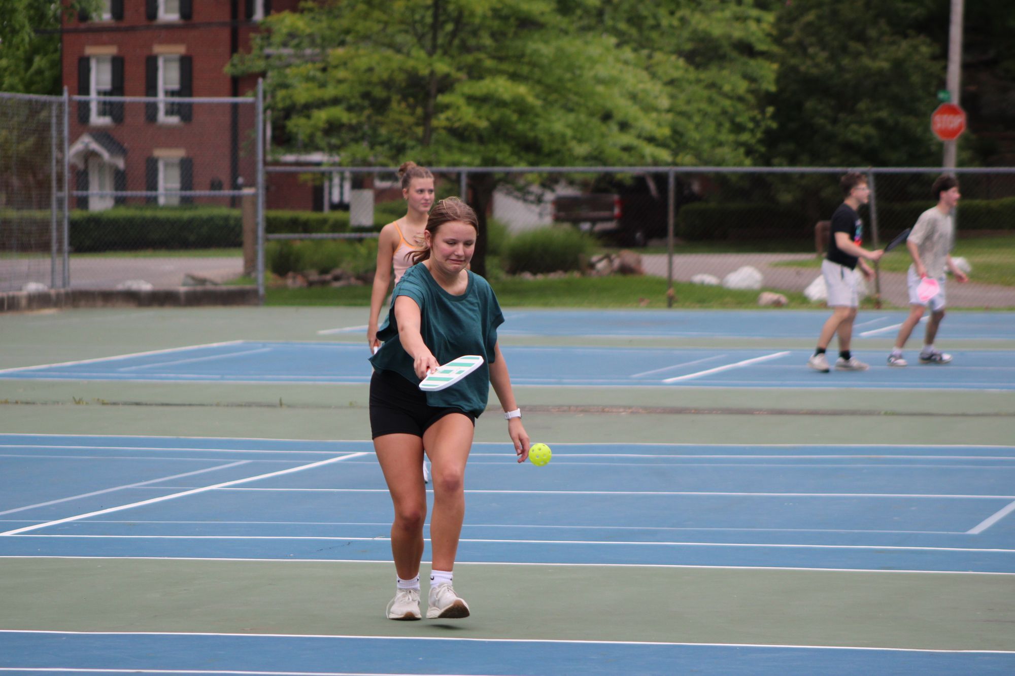 Friends playing pickleball together on outdoor courts